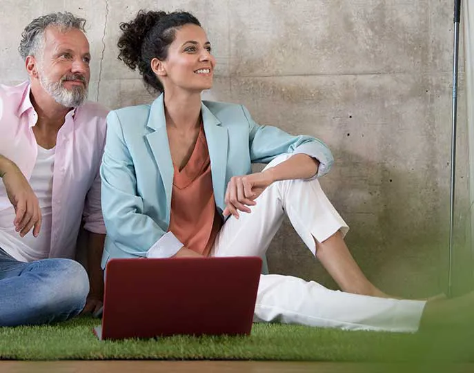 Pareja sentada sobre cómodo césped artificial VerdePRO
